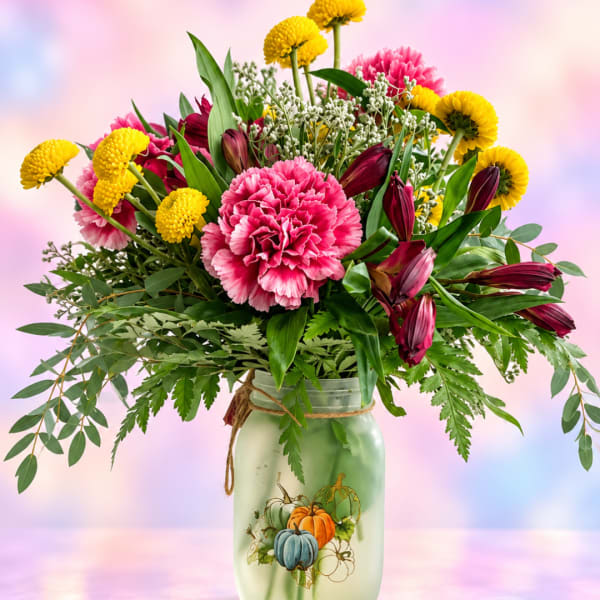 Pink and yellow mixed bouquet in a painted mason jar vase
