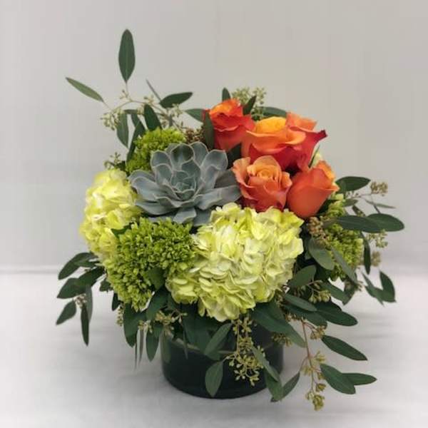 Orange roses and green hydrangeas in a black container