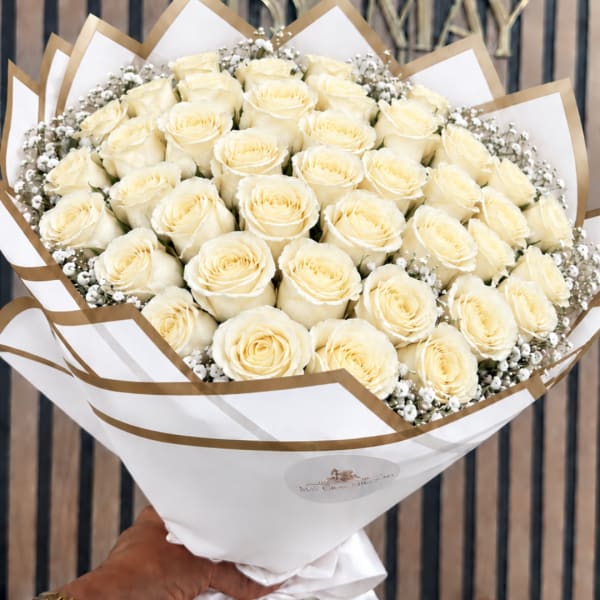 Bouquet of cream roses wrapped in white and gold paper