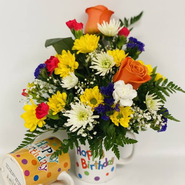 Birthday bouquet in a mug with yellow, white, red, and orange flowers