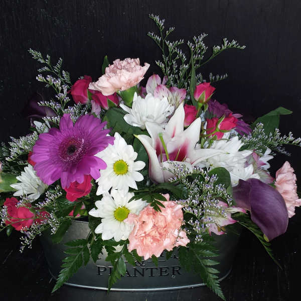 Mixed bouquet in a metal planter with pink, white, and purple flowers