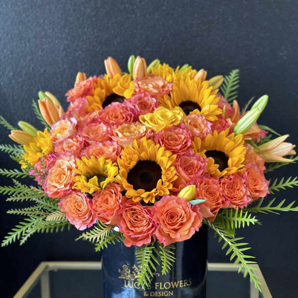 Bouquet of coral roses and yellow sunflowers in a black vase