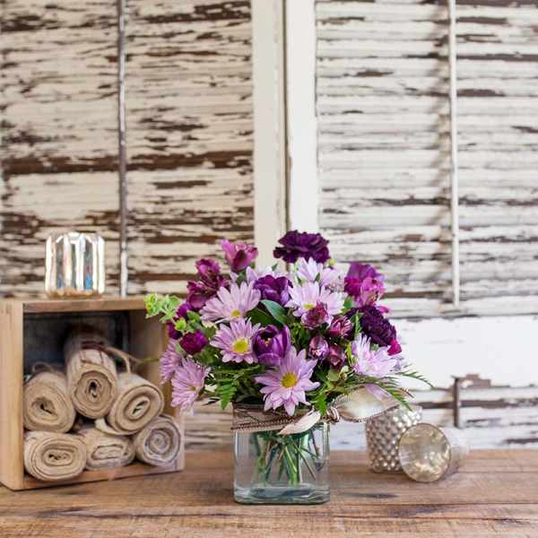 Purple and pink bouquet in a clear glass vase