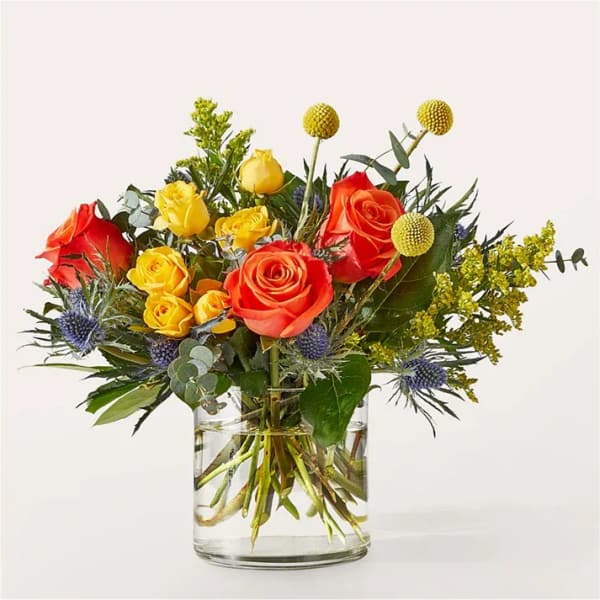 Bouquet of red and yellow roses in a clear glass vase
