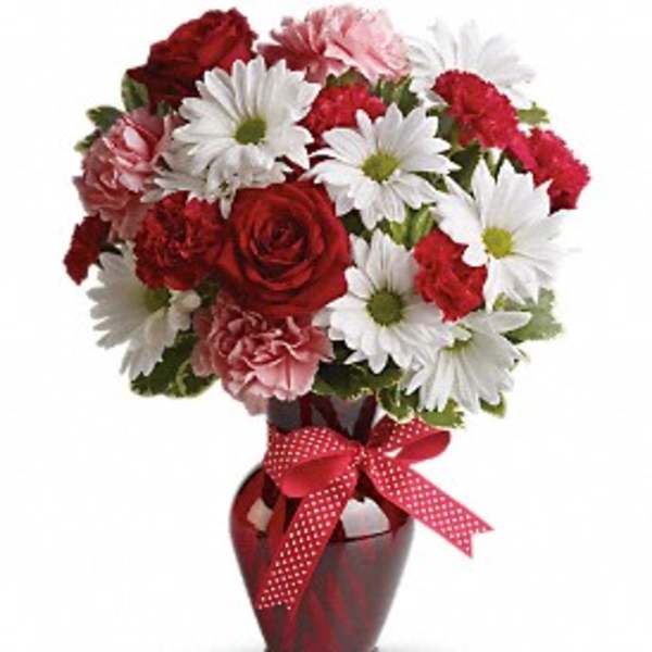 Red and white mixed bouquet in a red vase with a ribbon