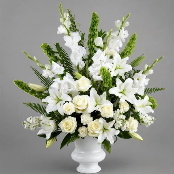White lilies and roses arranged in a white vase