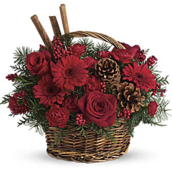 Red roses and gerbera daisies in a wicker basket with pinecones