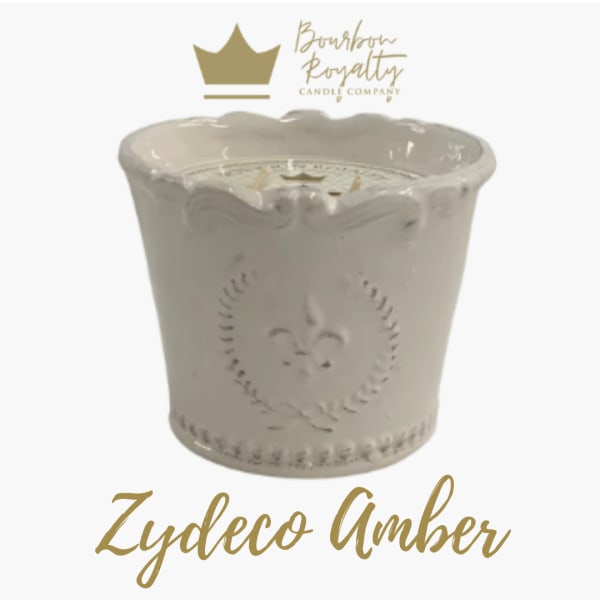Cream ceramic candle jar with a scalloped rim and gold logo text