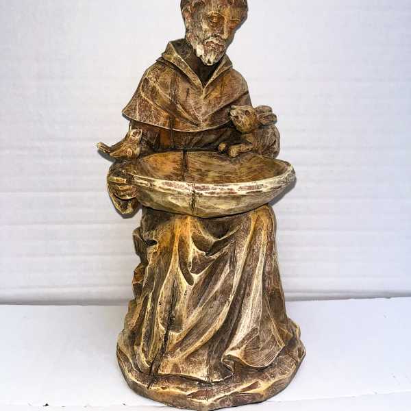 Wooden monk statue holding a shallow bowl with a bird and rabbit