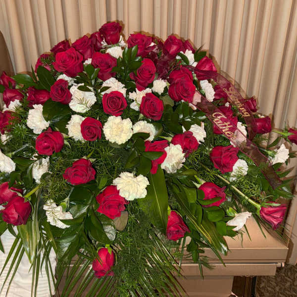 Large red rose and white carnation funeral spray with ribbon