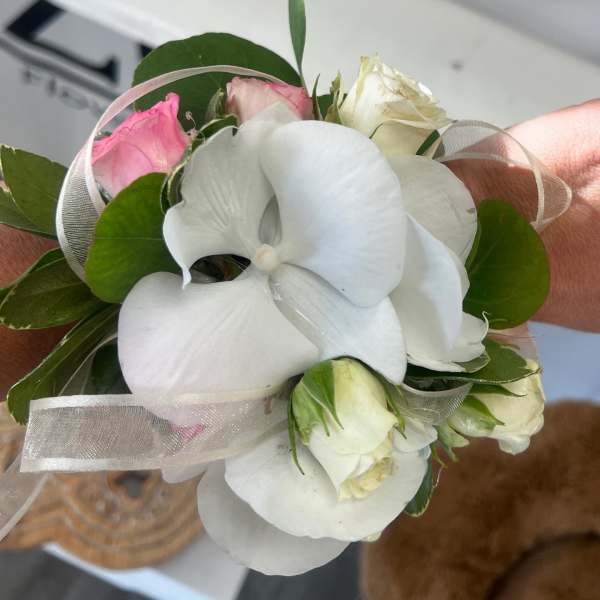 Small bouquet with white orchids and pink roses tied with sheer ribbon