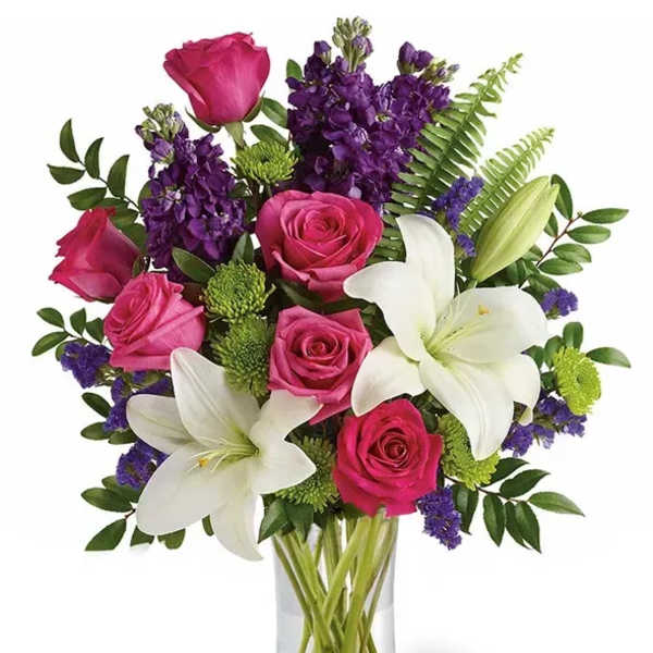 Pink roses and white lilies in a clear glass vase
