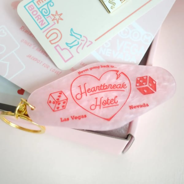 Pink keychain with a heart and "Heartbreak Hotel" text