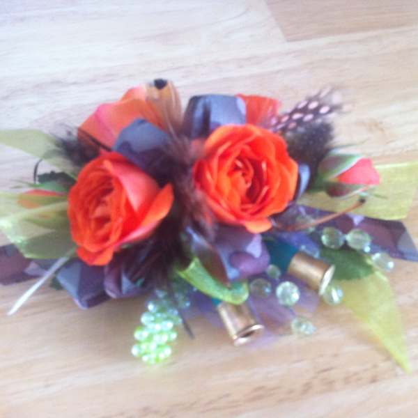 Small bouquet of orange roses with decorative beads and ribbon