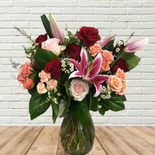 Mixed bouquet of roses and lilies in a glass vase