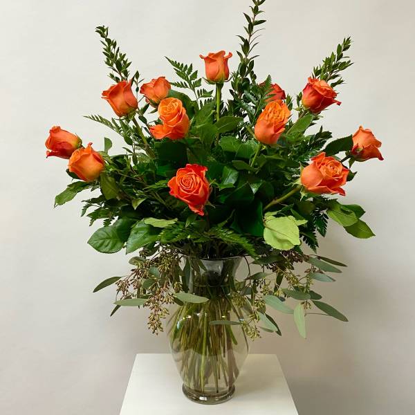 Orange roses arranged in a clear glass vase