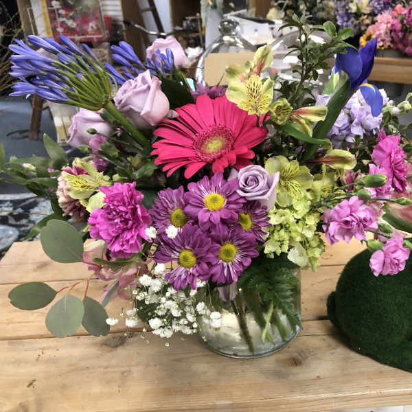 Mixed bouquet in a glass vase beside a green bunny figurine
