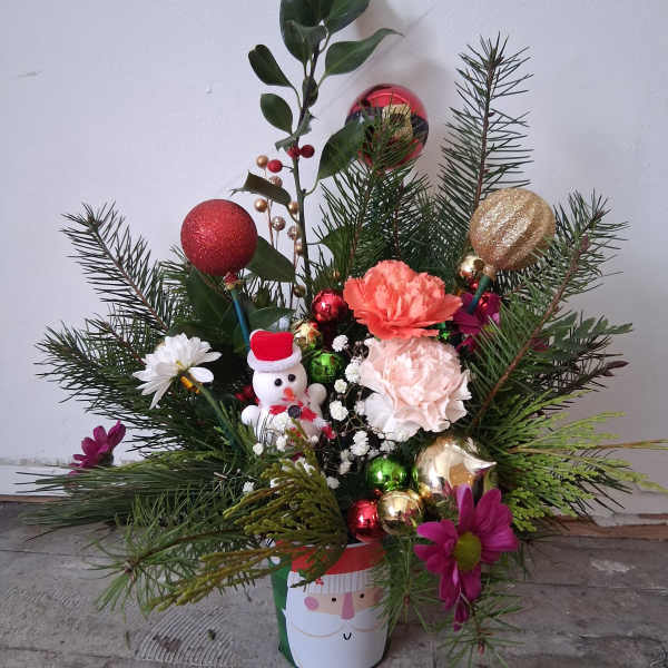 Holiday arrangement with carnations, ornaments, and a snowman in a Santa hat