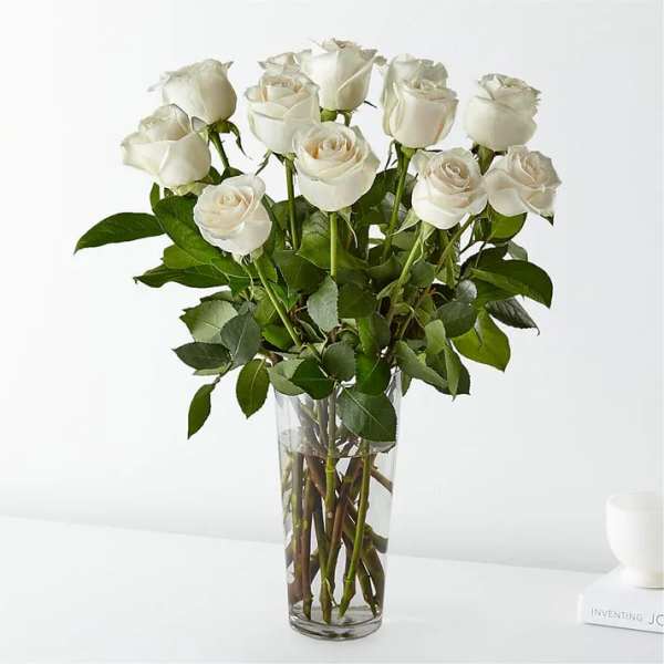 White roses arranged in a clear glass vase