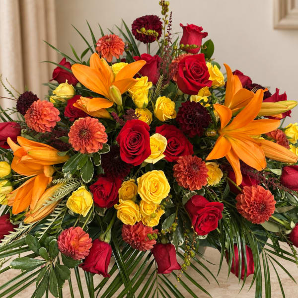 Large bouquet of red, yellow, and orange flowers in a room
