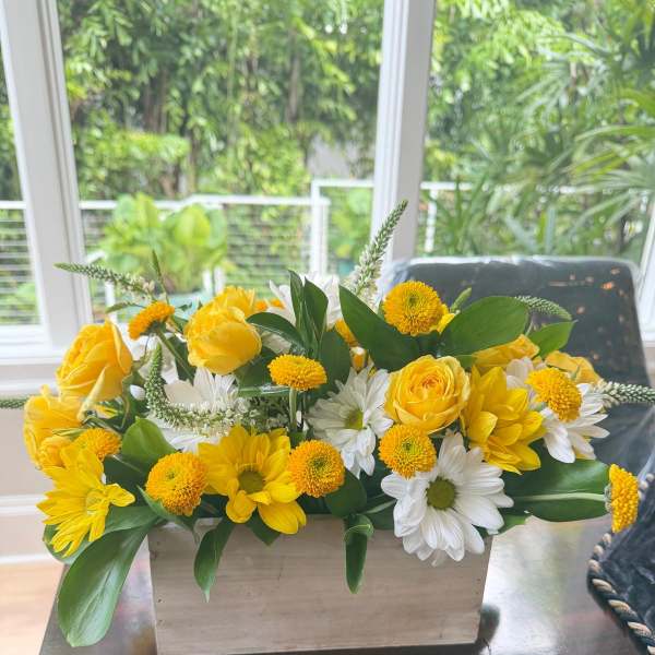 Yellow roses and white daisies in a rectangular wooden planter