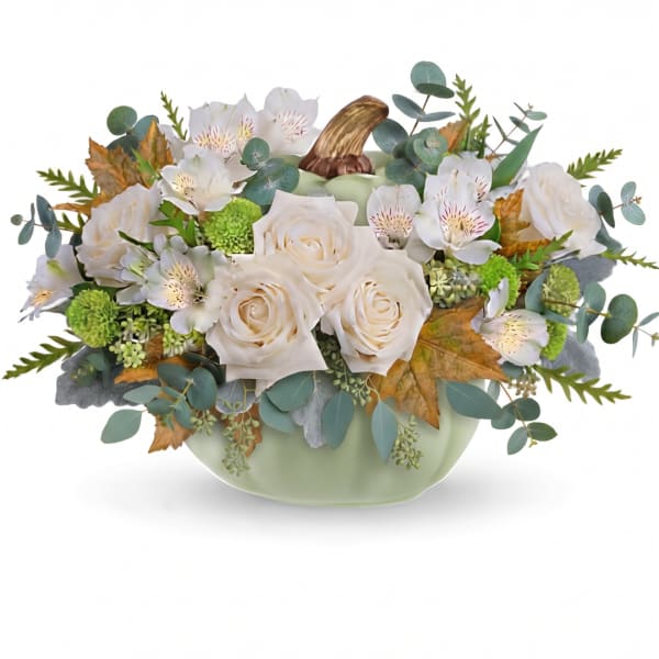 Cream roses and white flowers arranged in a pale green vase