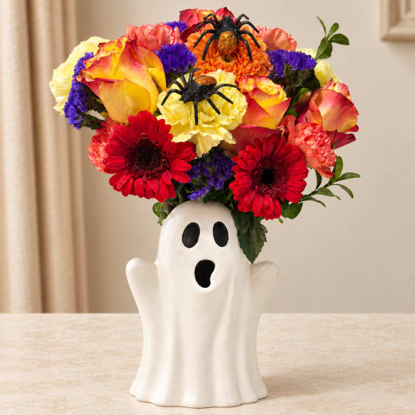 Colorful bouquet in a ghost-shaped ceramic vase with spider decorations