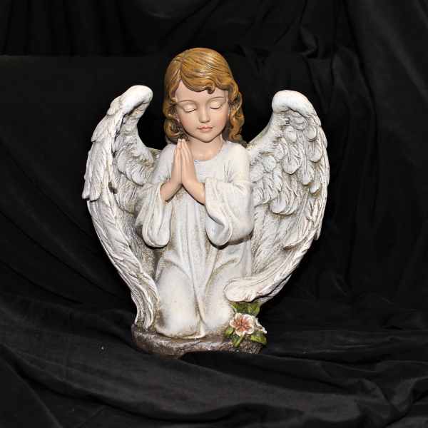 White angel statue with folded hands and wings