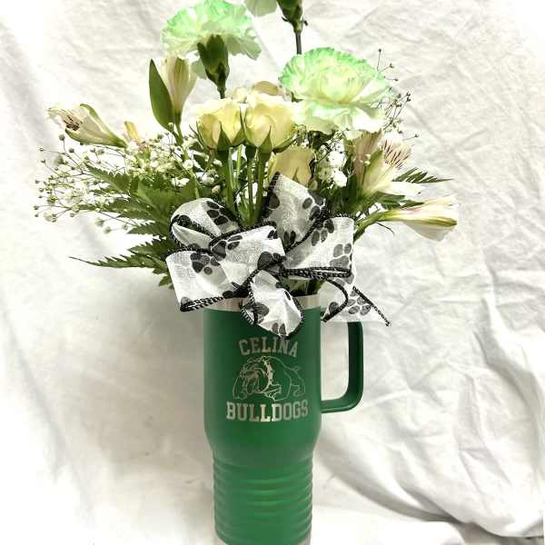 White and pale green flowers in a green travel tumbler with a bow
