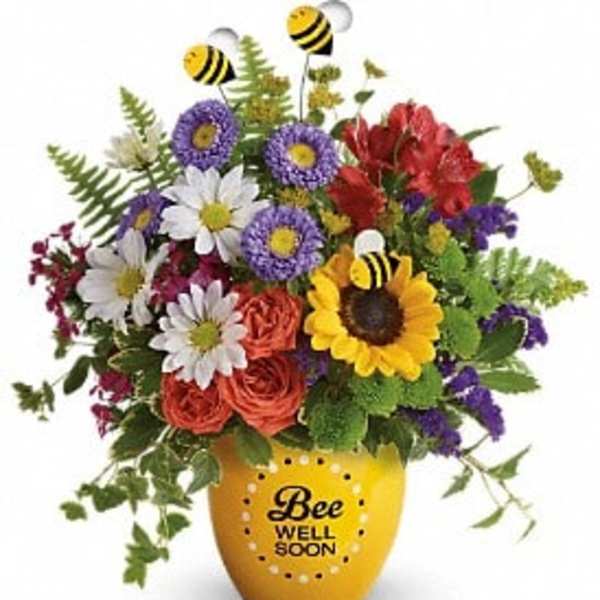 Colorful bouquet in a yellow vase with bee decorations and a "Bee Well Soon" message