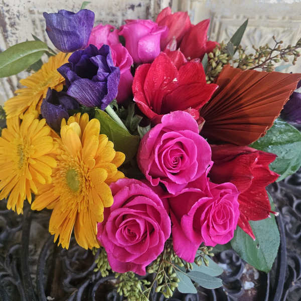 Bouquet of pink roses, purple blooms, and yellow daisies