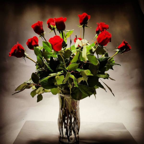 Red roses arranged in a clear glass vase
