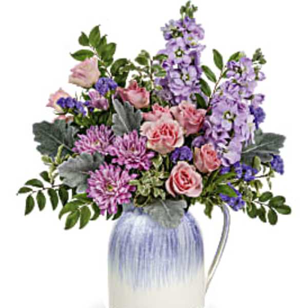 Mixed pink and purple flowers in a blue-and-white ceramic pitcher