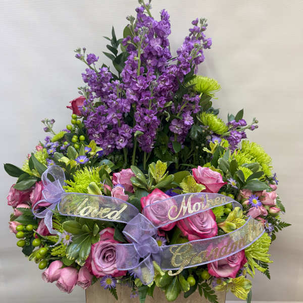 Purple and pink floral arrangement with ribbon labels for family members
