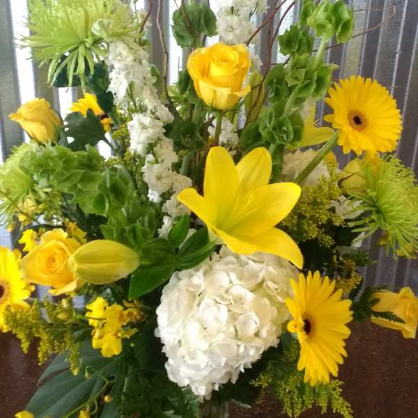 Yellow and white floral arrangement in a clear glass vase