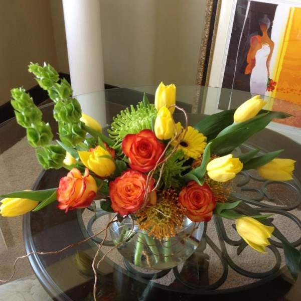 Bouquet of orange roses and yellow tulips in a glass vase