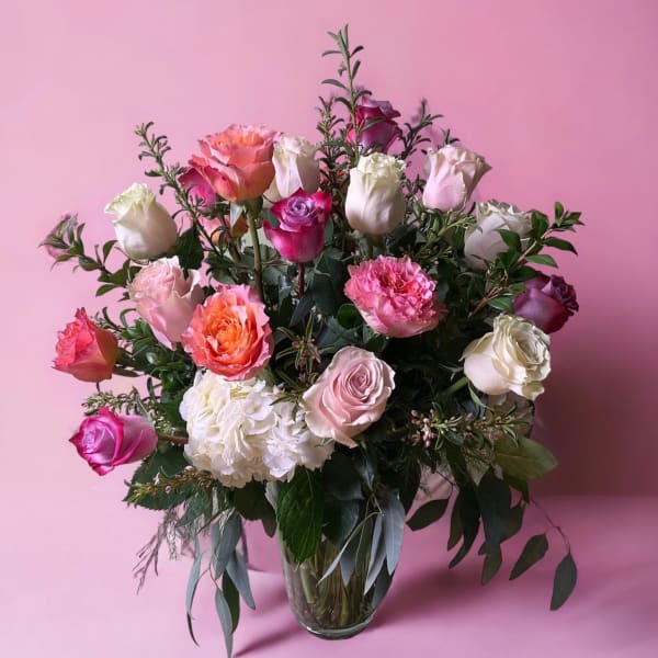 Mixed pink and white roses in a clear glass vase