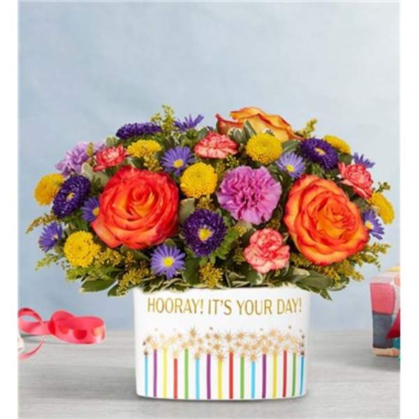 Colorful bouquet of roses, carnations, and daisies in a white gift box
