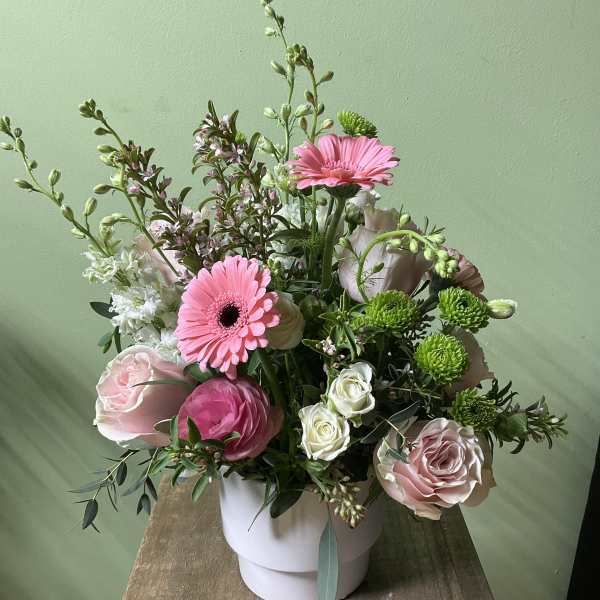Pink gerbera daisies and roses in a white vase