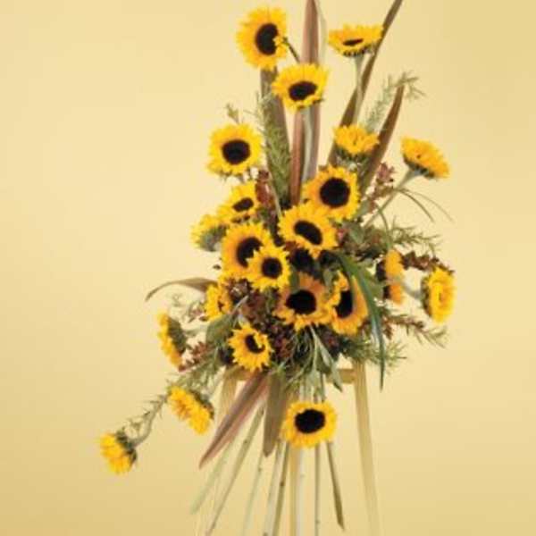 Tall sunflower arrangement on a stand with long ribbon streamers