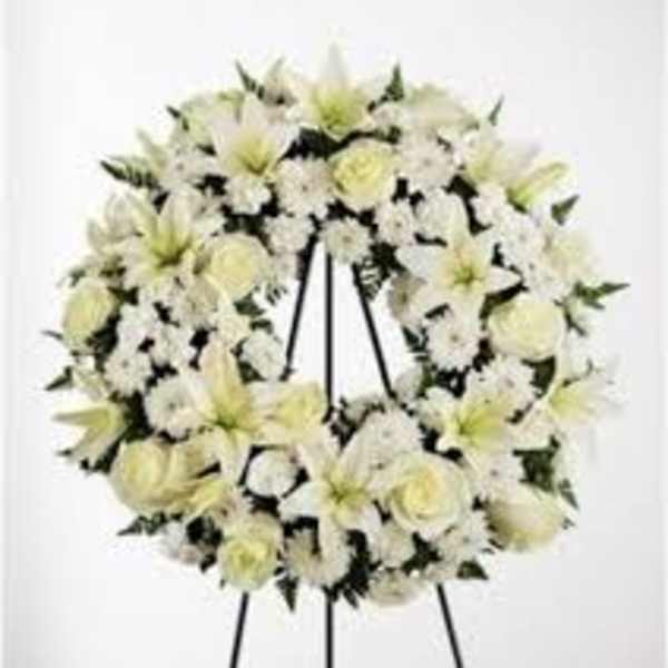 White floral wreath on a black easel stand