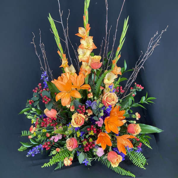 Tall floral arrangement with orange lilies and peach roses