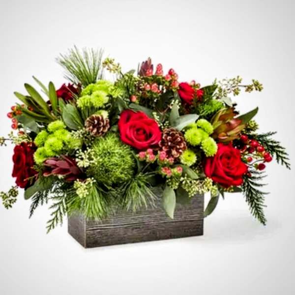 Red roses and green flowers in a rectangular wooden box