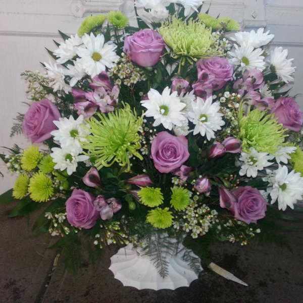 Pink roses and white daisies in a white vase arrangement