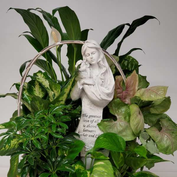 Basket of green houseplants with a white angel statue centerpiece