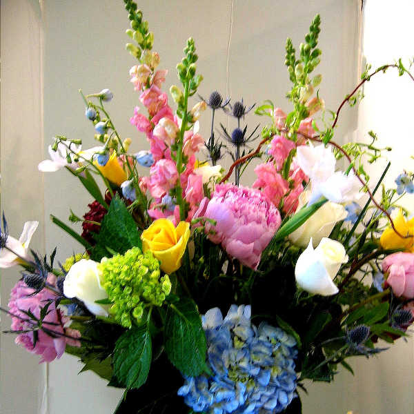 Mixed bouquet with hydrangea, roses, snapdragons, and calla lilies in a vase