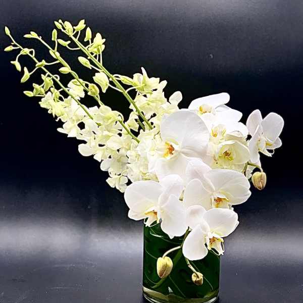 White orchids arranged in a green glass vase