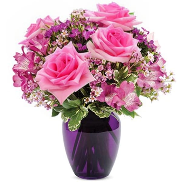Pink roses and purple flowers arranged in a purple vase