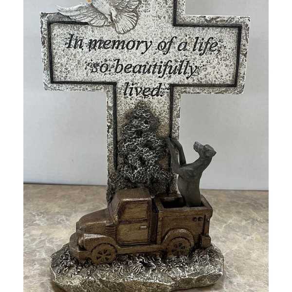 Memorial cross with a dove and truck figurine