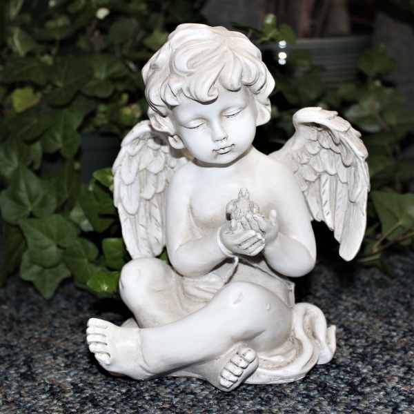 White angel figurine holding a small bird